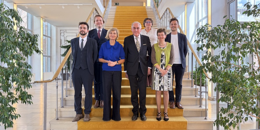 Minister Crevits, het voltallige Merksemse districtscollege en de districtssecretaris van Merksem poseren op de trap in het districtshuis
